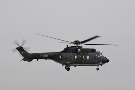 A military helicopter in flight over Payerne Air Base in Switzerland, showcasing Swiss aviation.