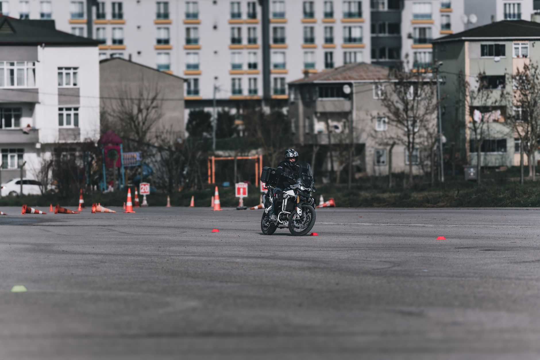 winger accelerating through cones on a wet training pitch while teammates watch from the touchline