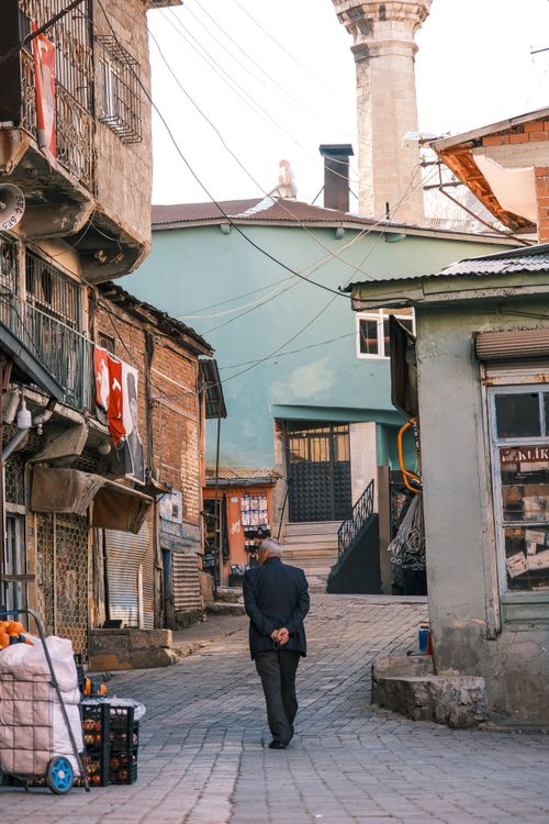 Free An elderly man walks in a charming alley in Turkey, surrounded by traditional architecture. Stock Photo