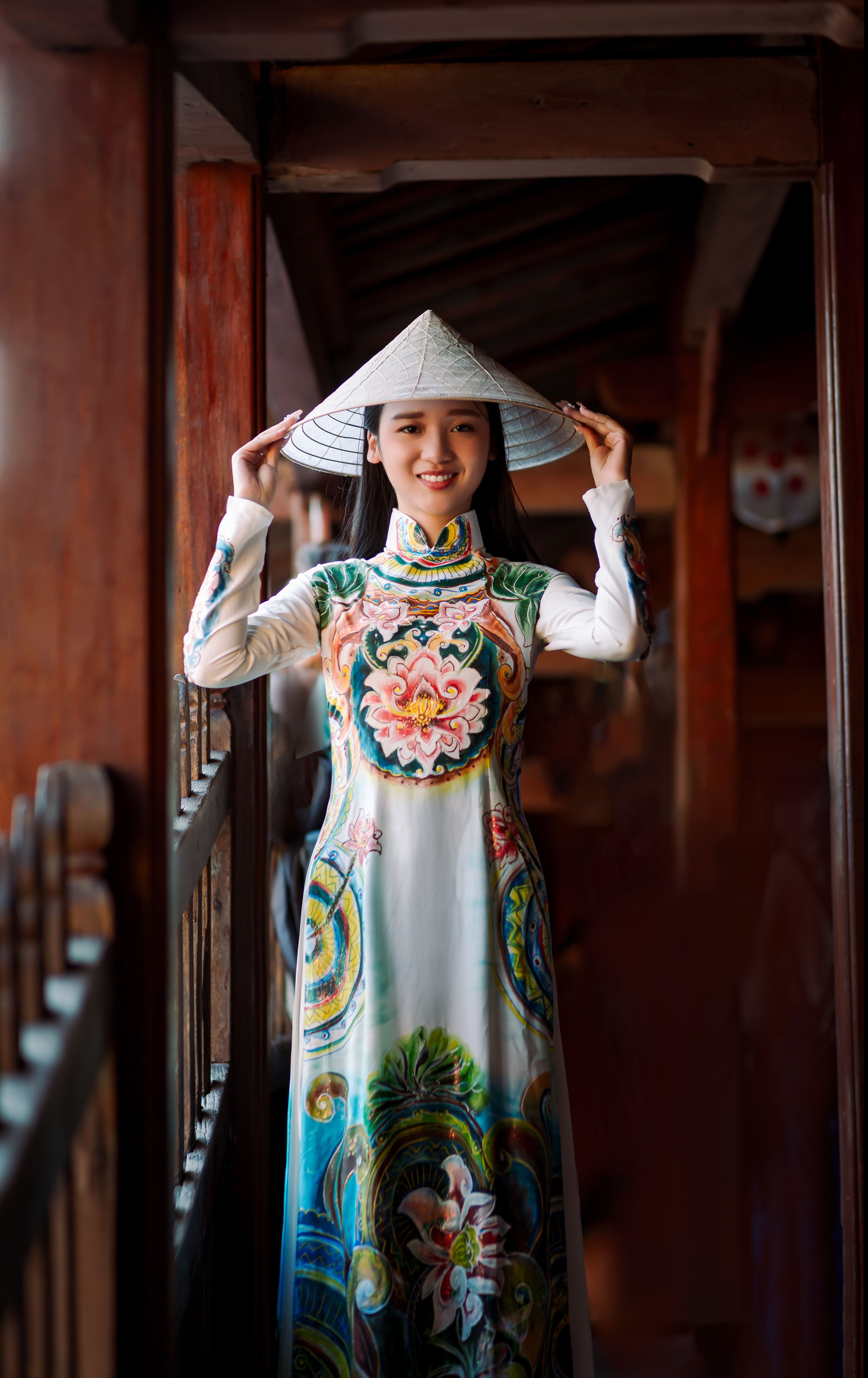 A young woman wearing a traditional Ao Dai and conical hat in Hội An, Vietnam.