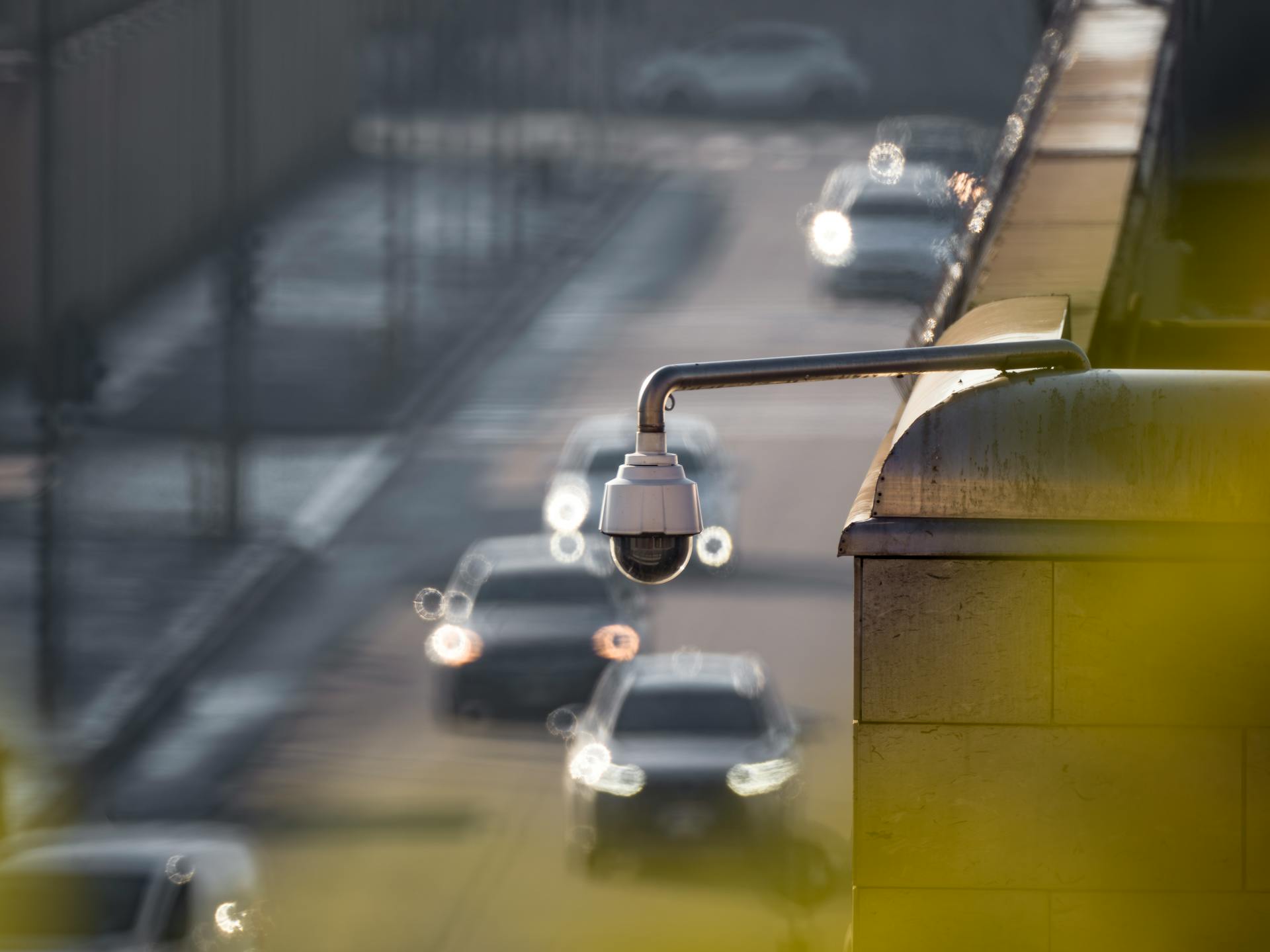 CCTV camera monitoring city traffic on a busy road with blurred vehicles in the background.