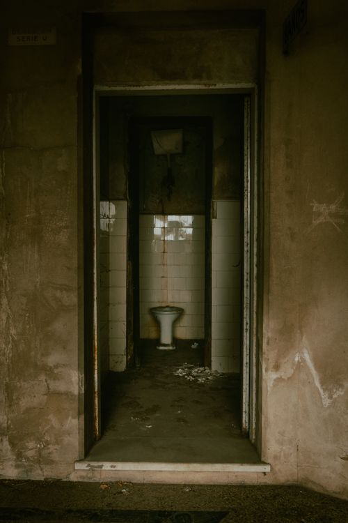 Free Eerie dark hallway leading to an abandoned bathroom in Rosario, Argentina. Stock Photo