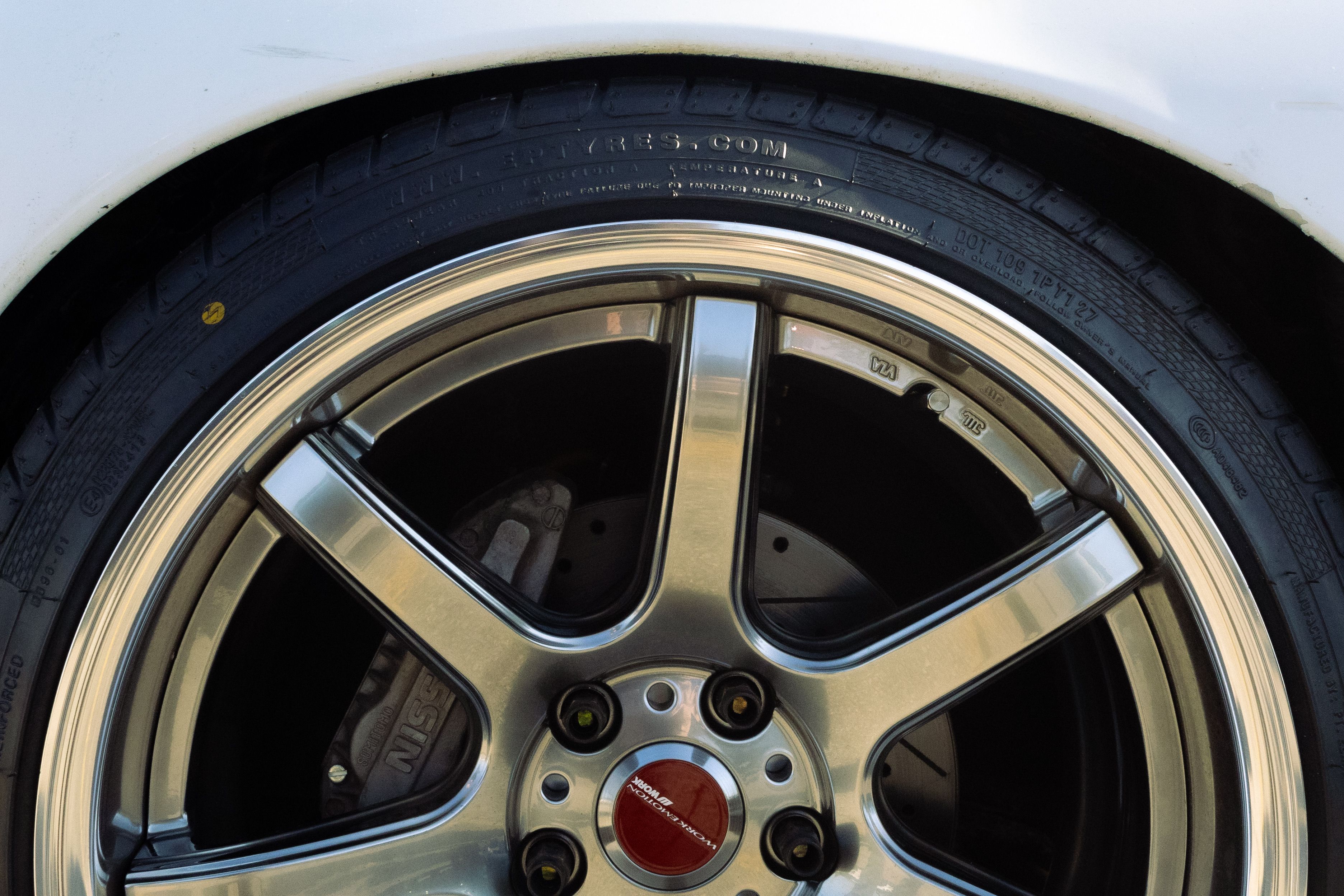 gratis Gedetailleerde close-up van een lichtmetalen velg en band op een aangepaste auto. Stockfoto