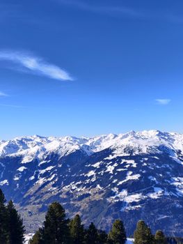 Panoramic view of snow-covered Alpine mountains against a clear blue sky.