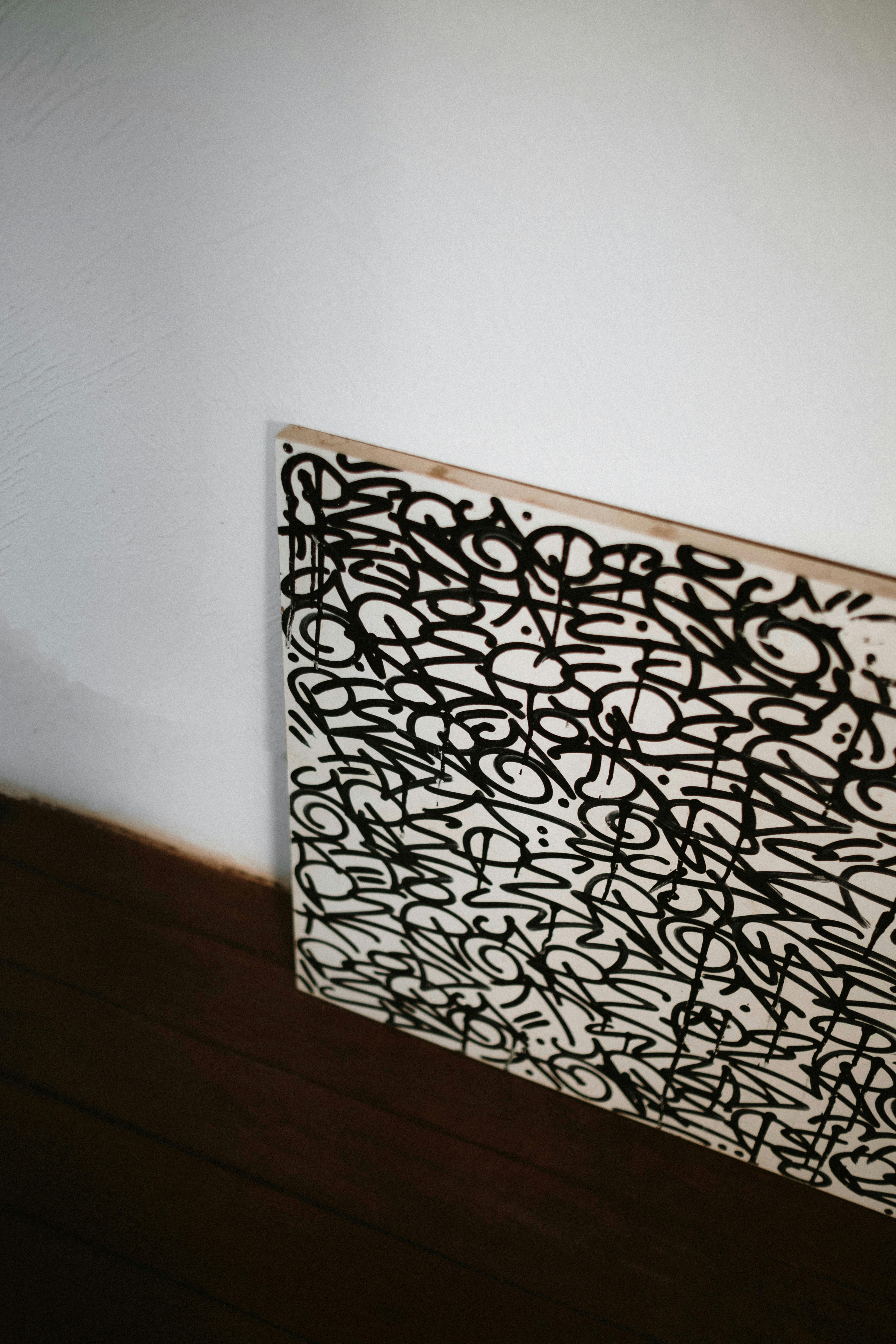 Gratis Minimalistisk bilde med abstrakt graffitikunst på lerret mot en vanlig vegg, og tilbyr rikelig med kopiplass. Arkivbilde