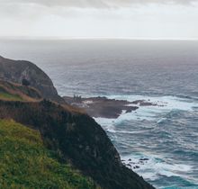 Coastal cliffs under a cloudy sky — photo by Artem Stoliar on Pexels
