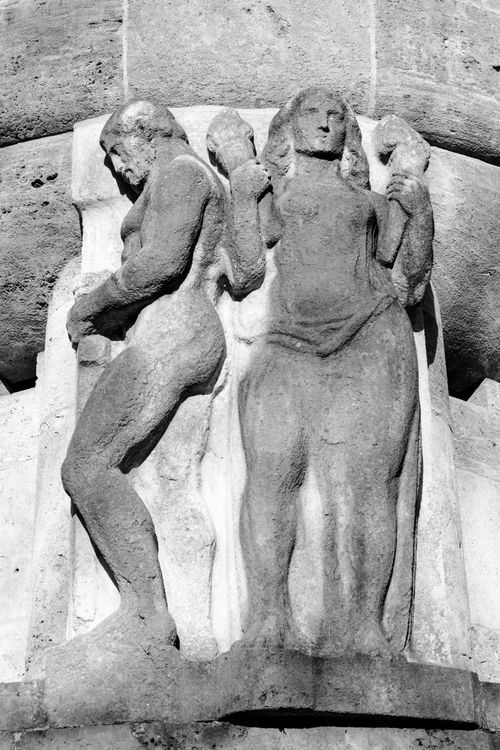 Free Intricate stone sculpture depicting human figures bathed in dramatic light. Stock Photo