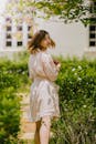 一位身穿白色连衣裙的年轻女子穿过宁静的花园