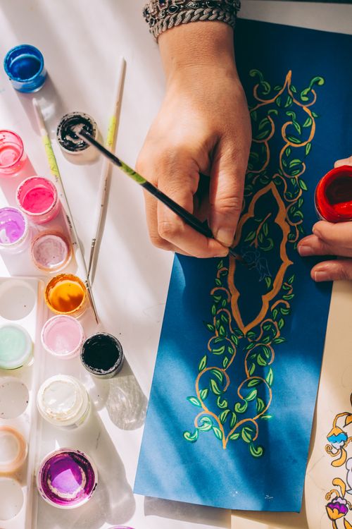 Free Artistic hand painting intricate design on paper using vibrant colors and brushes. Stock Photo