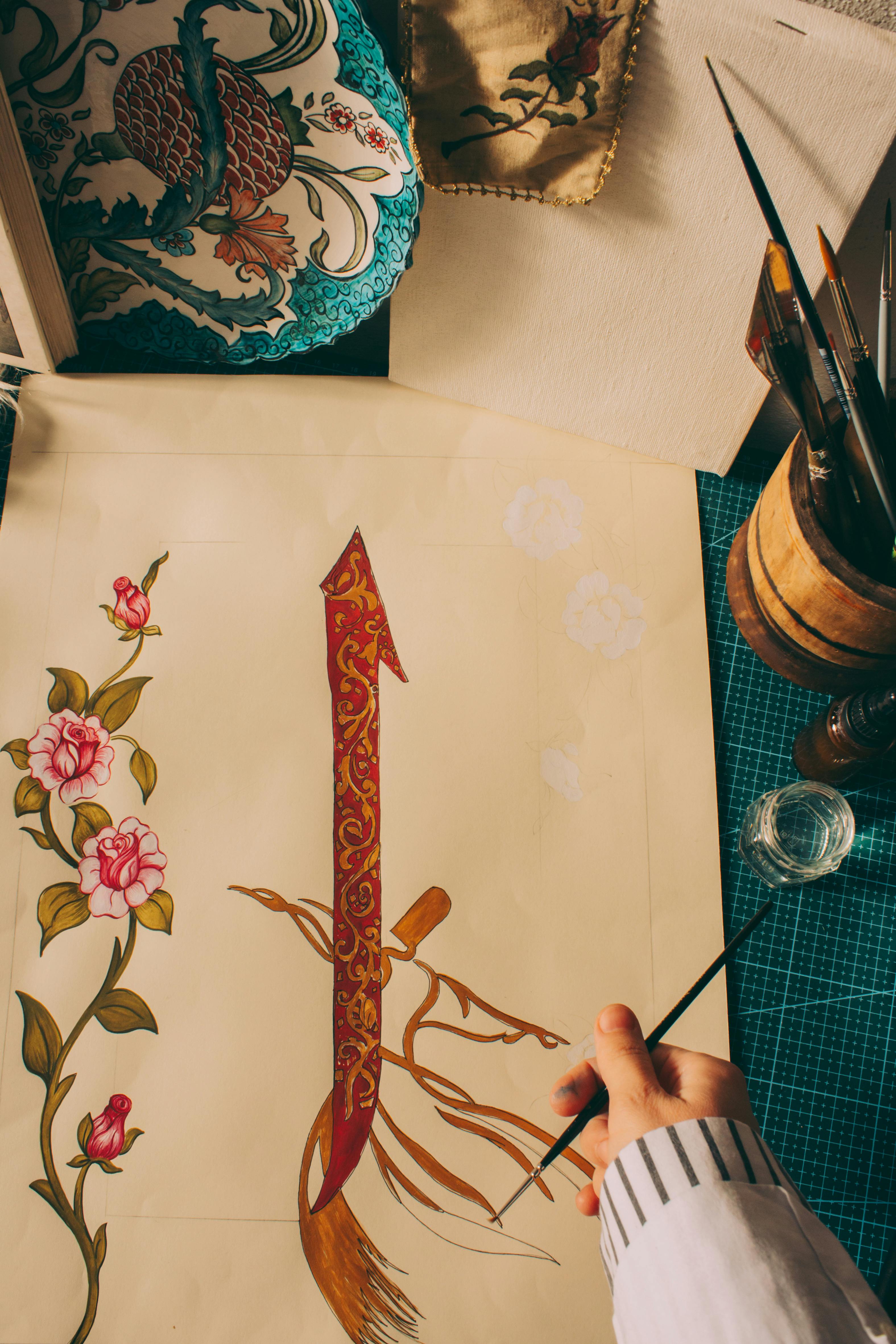 Hand painting traditional Turkish floral design with ornate details and calligraphy.