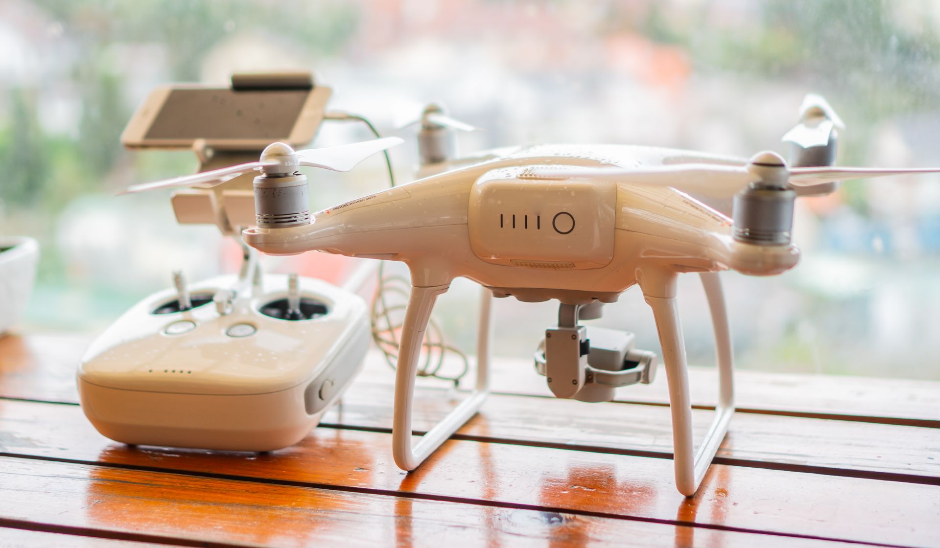 Close-up of a drone and controller on a table, indoor setting with a modern design.