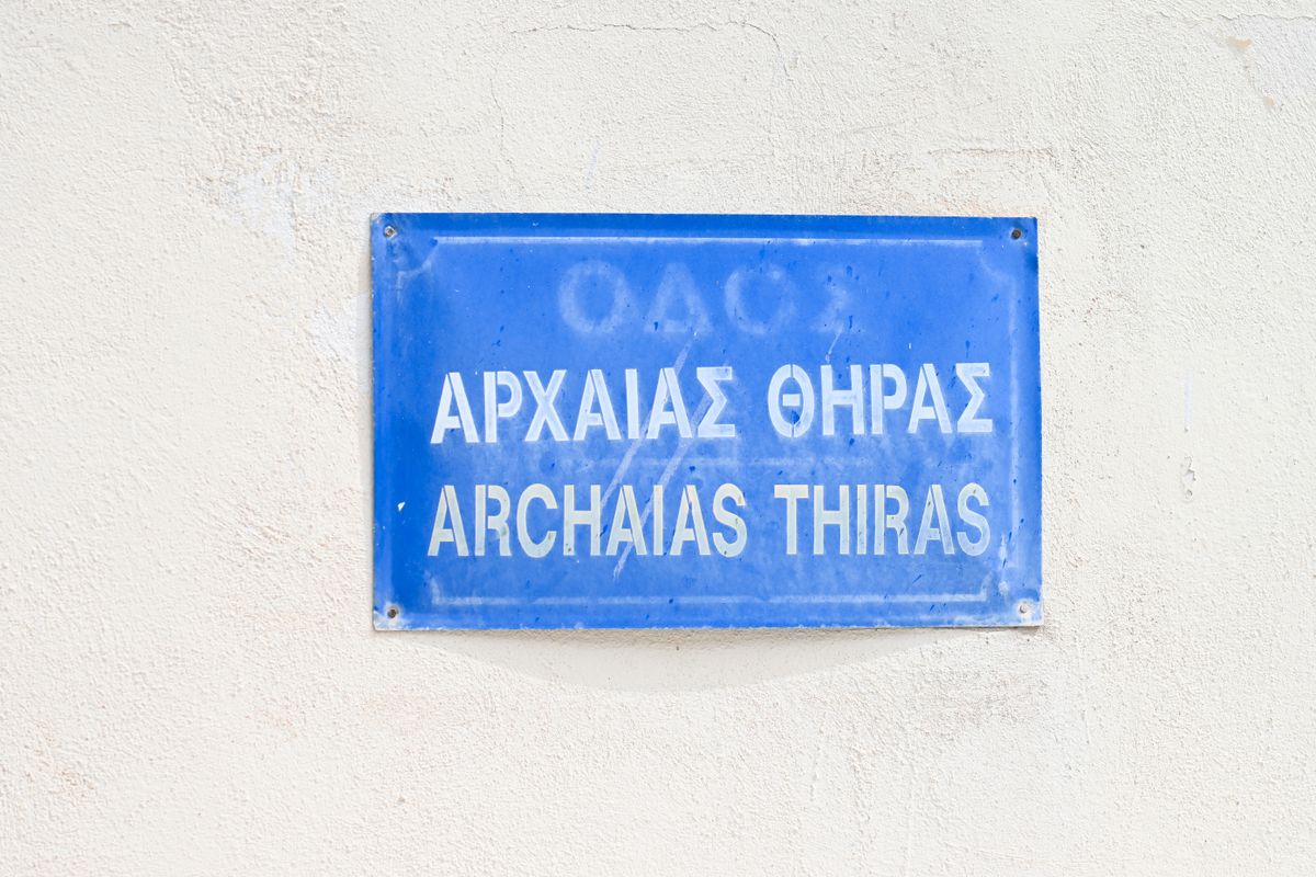 Placuta albastra de strada bilingva, cu text grecesc si transliterare