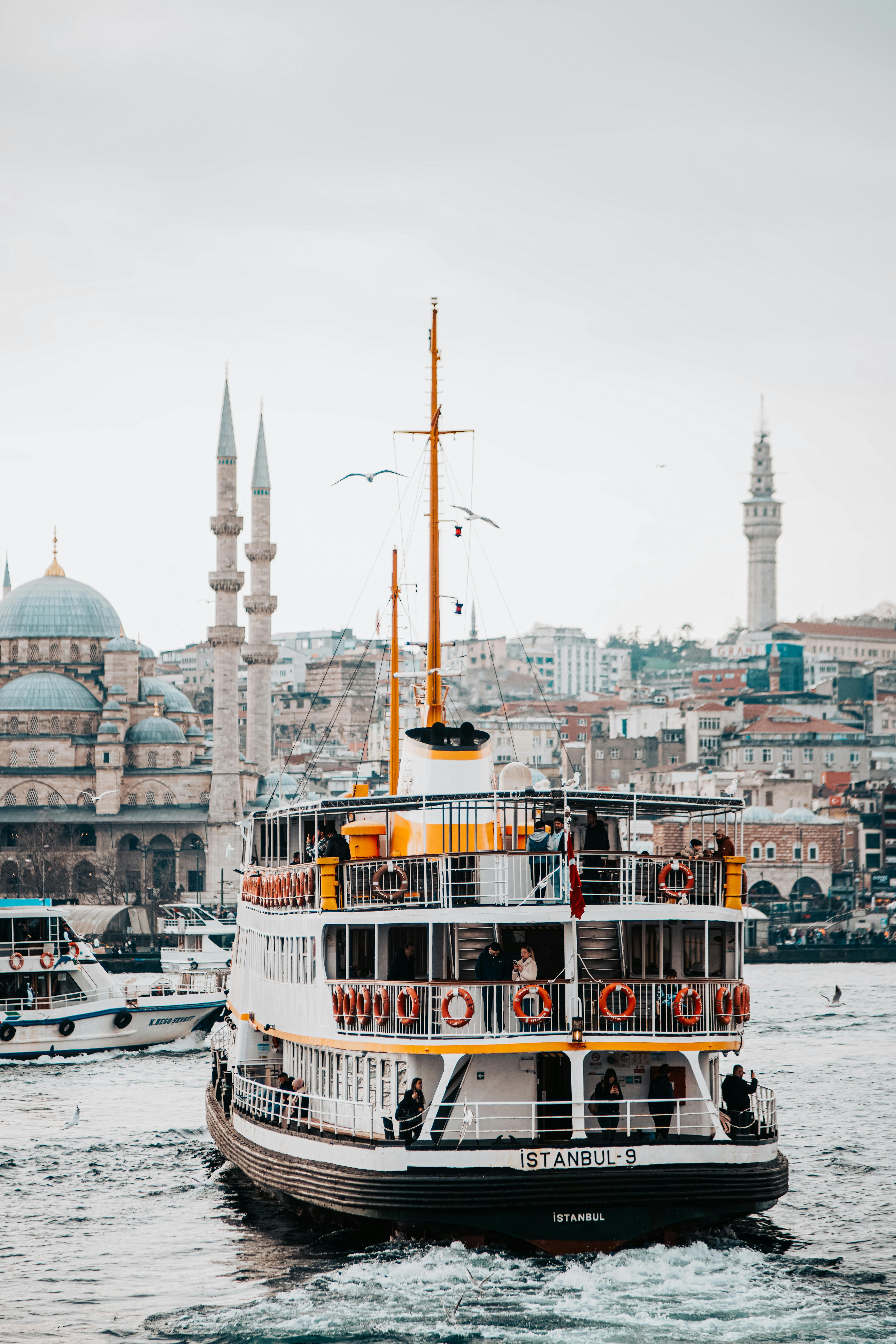 Gratuit Un ferry de passagers navigue sur les eaux avec l'horizon emblématique d'Istanbul et les mosquées en arrière-plan. Photos