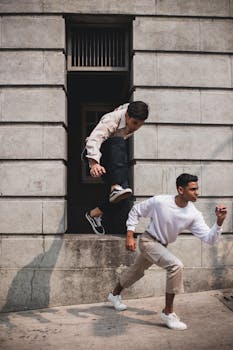 两名穿着休闲装的年轻男子在充满活力的城市环境中被捕捉到，展现了运动与风格