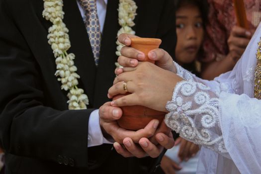 Close-up of a Sundanese wedding ceremony with clay jug ritual in West Java.