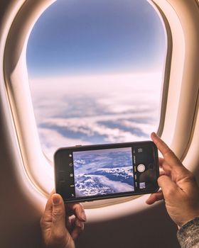 Photo of snowy mountains taken through an airplane window, with smartphone.