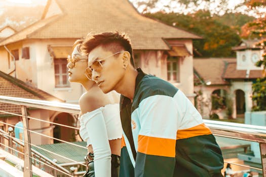 一对时尚的年轻夫妇戴着太阳镜，在充满活力的城市环境中摆出户外姿势