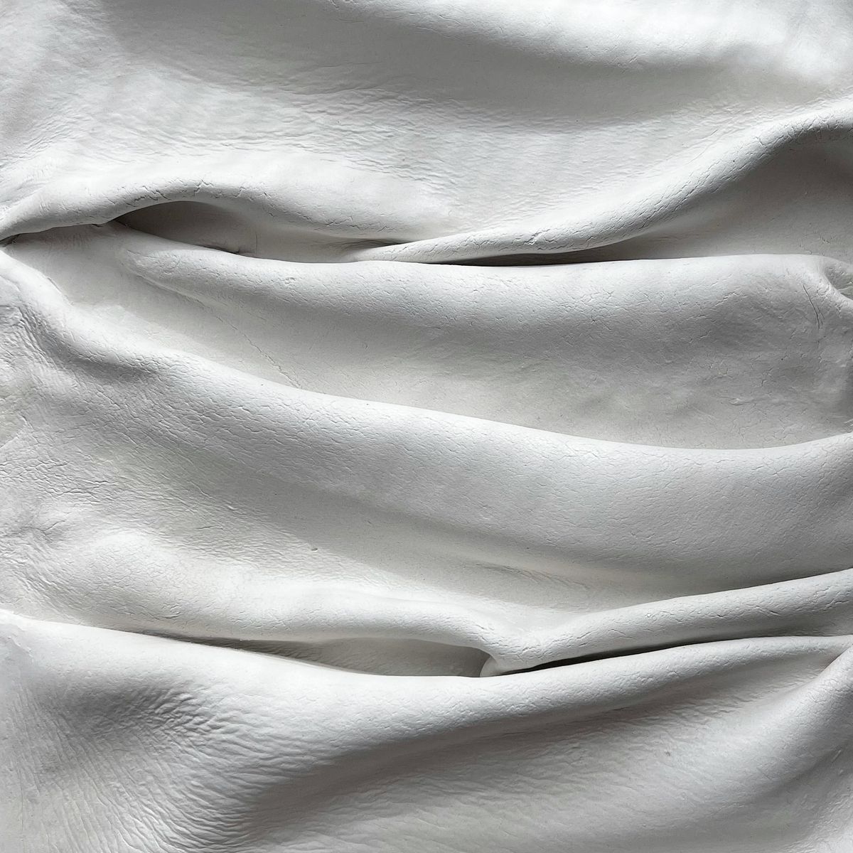 Folded white linen wrap photographed in soft studio light — Natalia S on Pexels