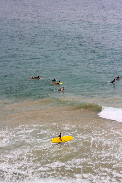 Free A group of surfers catching waves in Byron Bay, Australia from an aerial perspective. Stock Photo