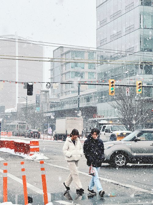 Free Urban scene with pedestrians crossing during a snowy winter day. Stock Photo
