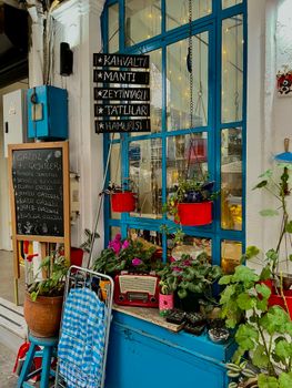 Inviting cafe entrance with vibrant plants and a vintage vibe.