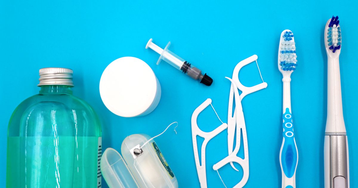 Oral care items including mouthwash, floss, and toothbrushes arranged on a blue background