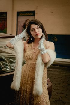 Elegant woman in vintage style posing outdoors, exuding timeless fashion and glamour.