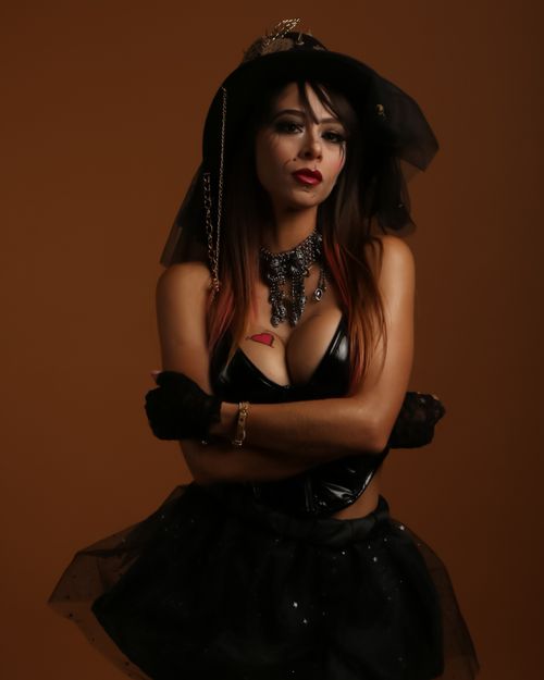 Free A woman dressed in gothic attire poses with dramatic lighting, exuding mystery and elegance. Stock Photo