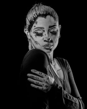 Artistic black and white portrait of a woman with unique makeup design.