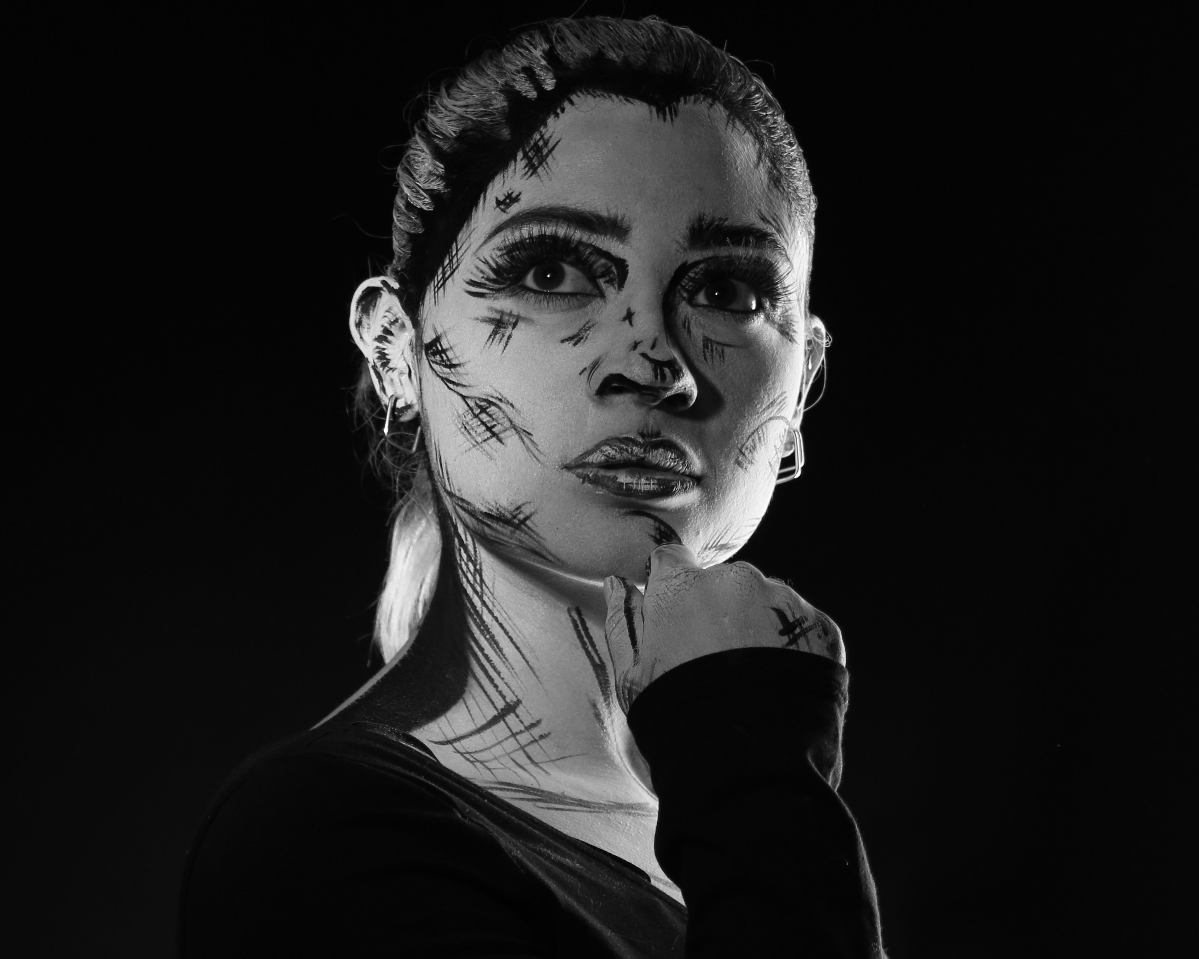 Monochrome portrait of a woman with artistic makeup, evoking a comic book style.