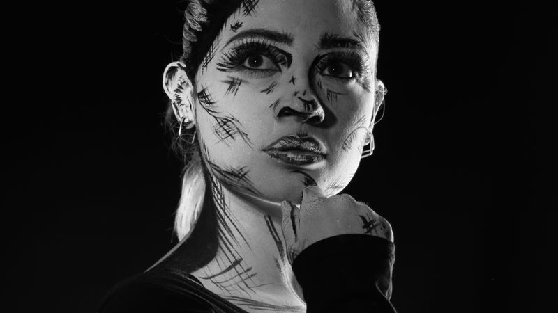 Monochrome portrait of a woman with artistic makeup, evoking a comic book style.