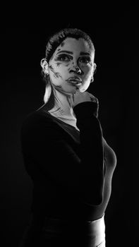 A captivating black and white portrait of a woman with artistic face paint, enhancing dramatic expression.