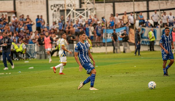 Intense soccer game showcasing players in action with enthusiastic crowd.