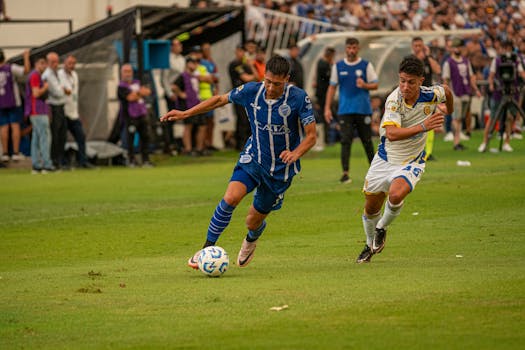 Two soccer players in action during a competitive match on a grass field.