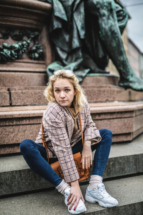 Free Fashionable woman posing by statue on a cloudy day in Munich, Germany. Stock Photo
