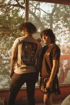 A fashionable couple poses indoors with a warm, nostalgic touch.