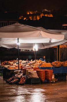 Illuminated night market fruit stall showcasing fresh produce under a canopy.