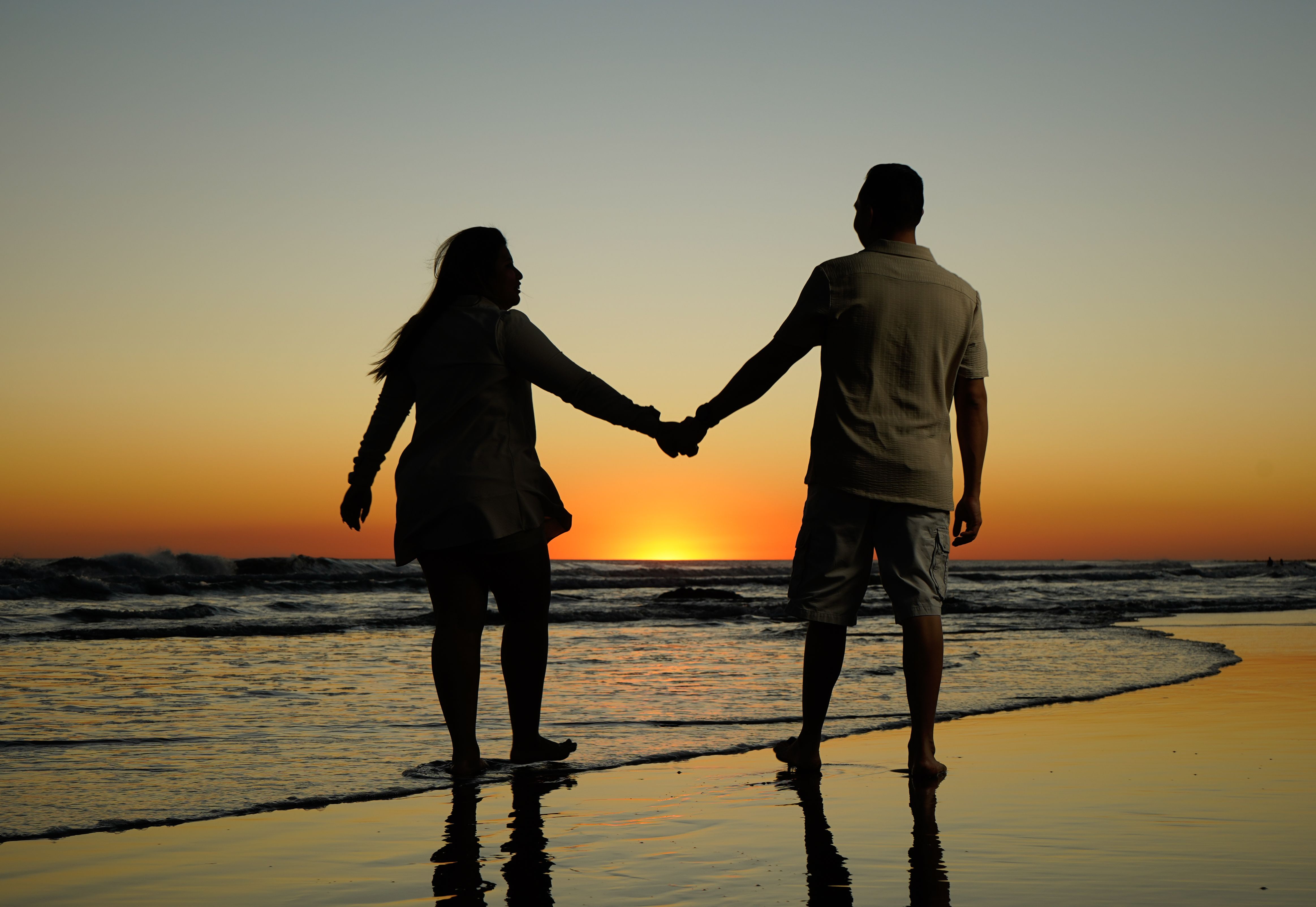Romantic Couple Holding Hands at Beach Sunset · Free Stock Photo