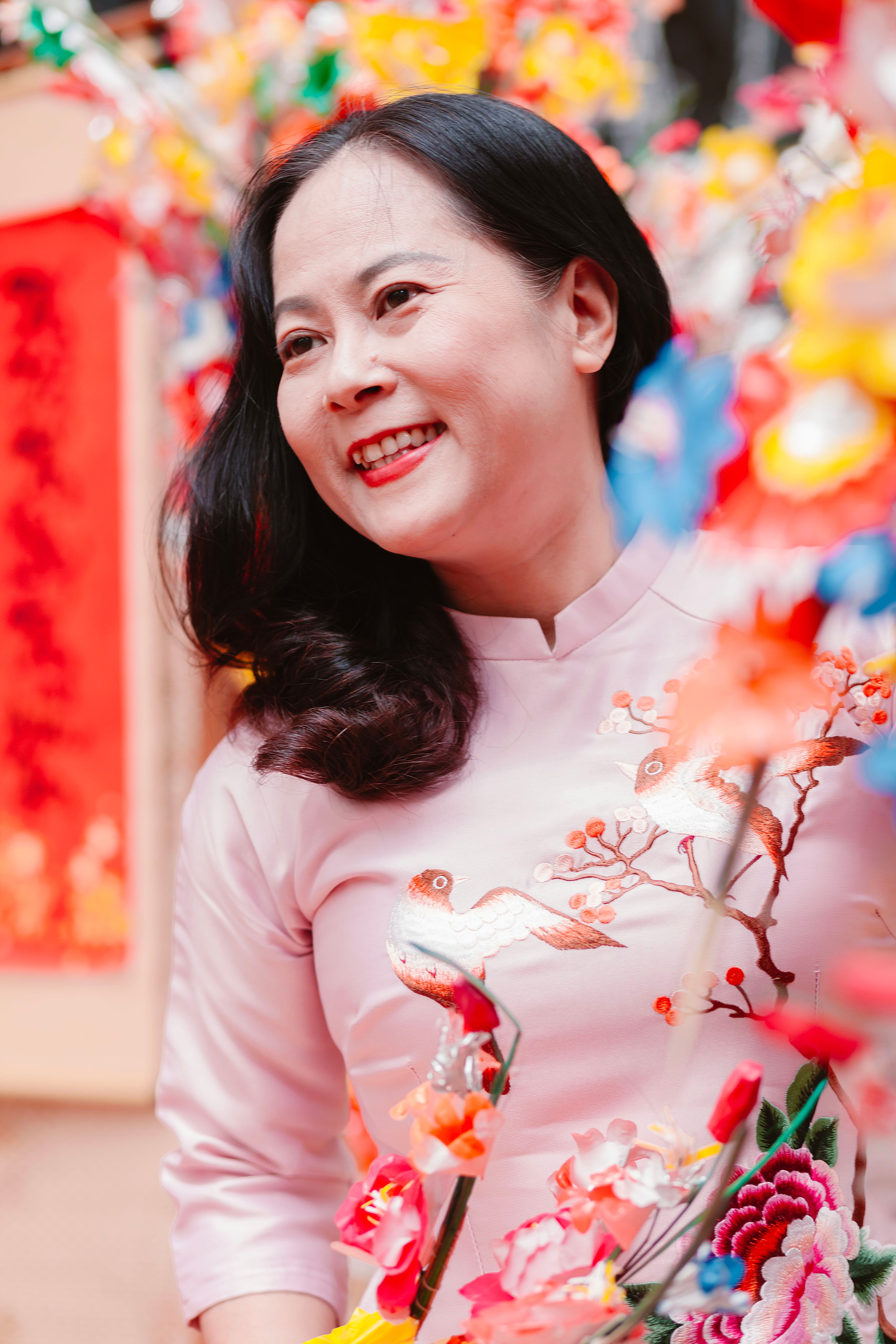 Joyful woman in traditional attire amid colorful festive decorations
