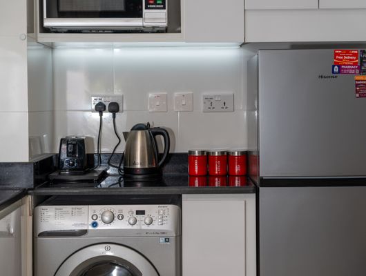 Kitchen with stainless steel refrigerator and washing machine at LG Best Shop Sikar