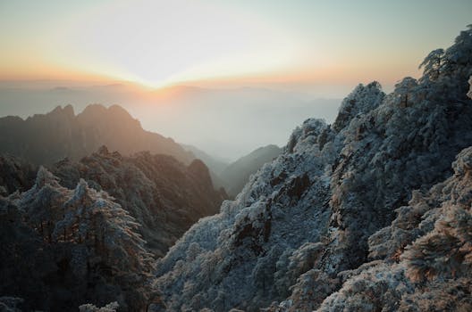 Breathtaking sunrise over snow-covered mountains, capturing the serene beauty of winter.