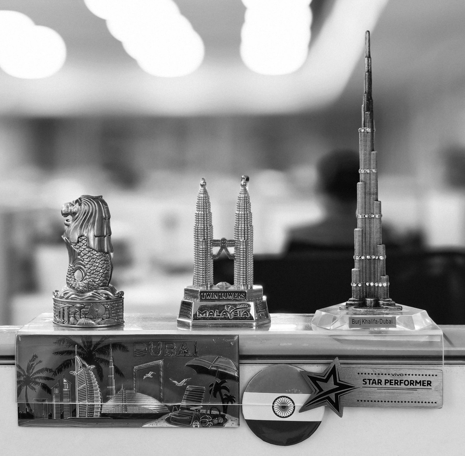 Black and white photo of iconic building miniatures on an office desk.