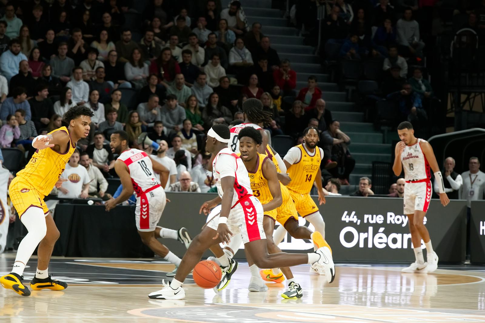 Basketball game action in an indoor arena