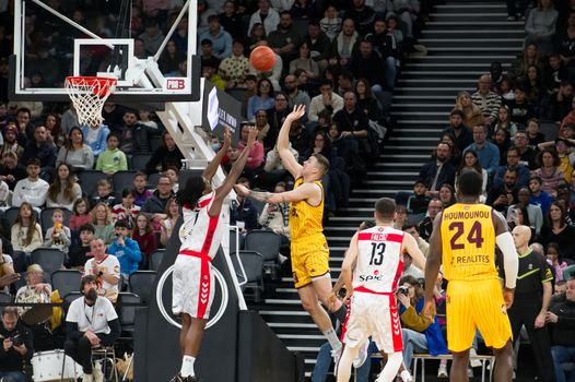 Dramatic moment in a basketball game with players and an engaged crowd.