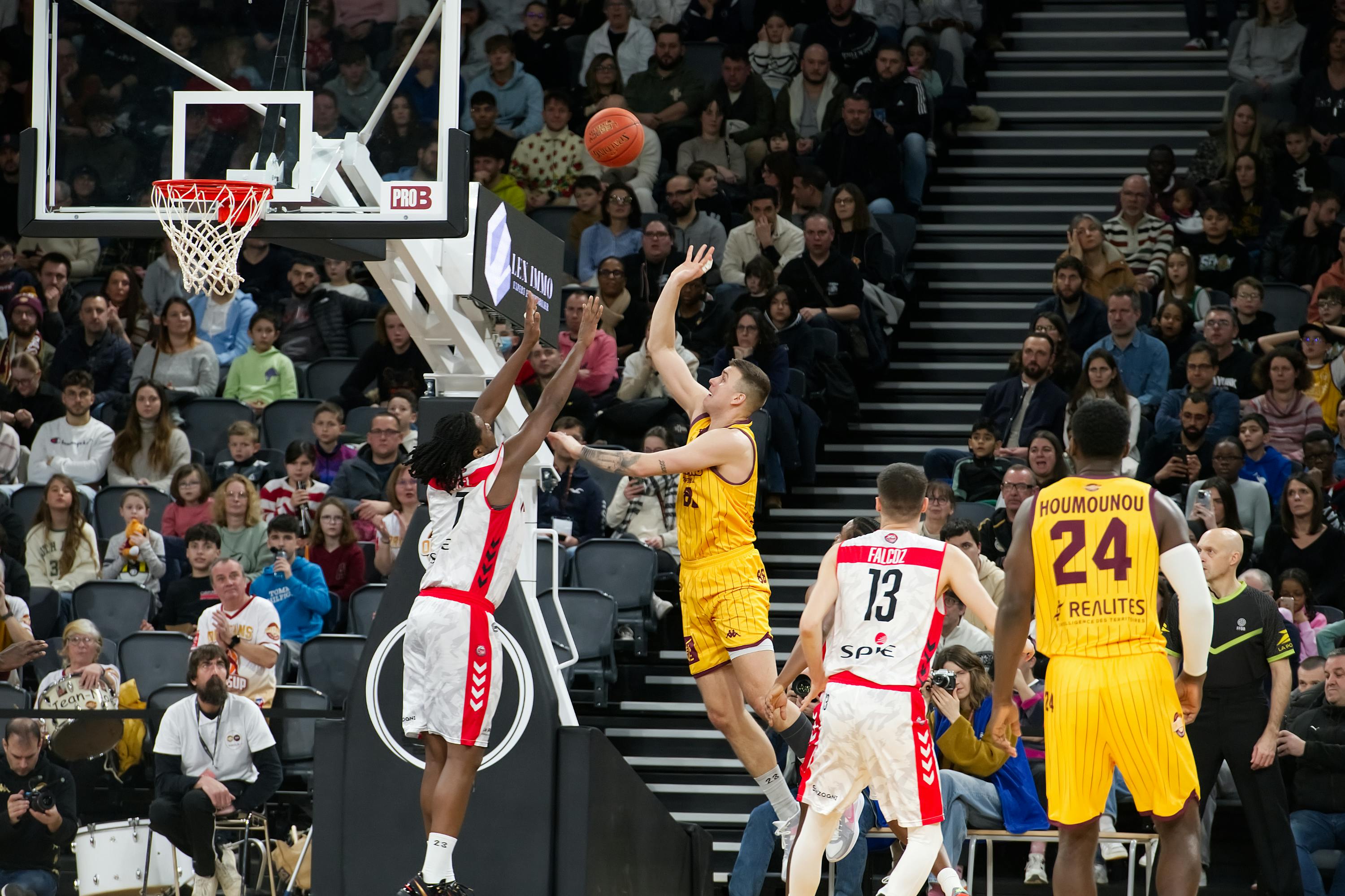 De franc Moment dramàtic en un partit de bàsquet amb jugadors i un públic compromès. Foto d'estoc