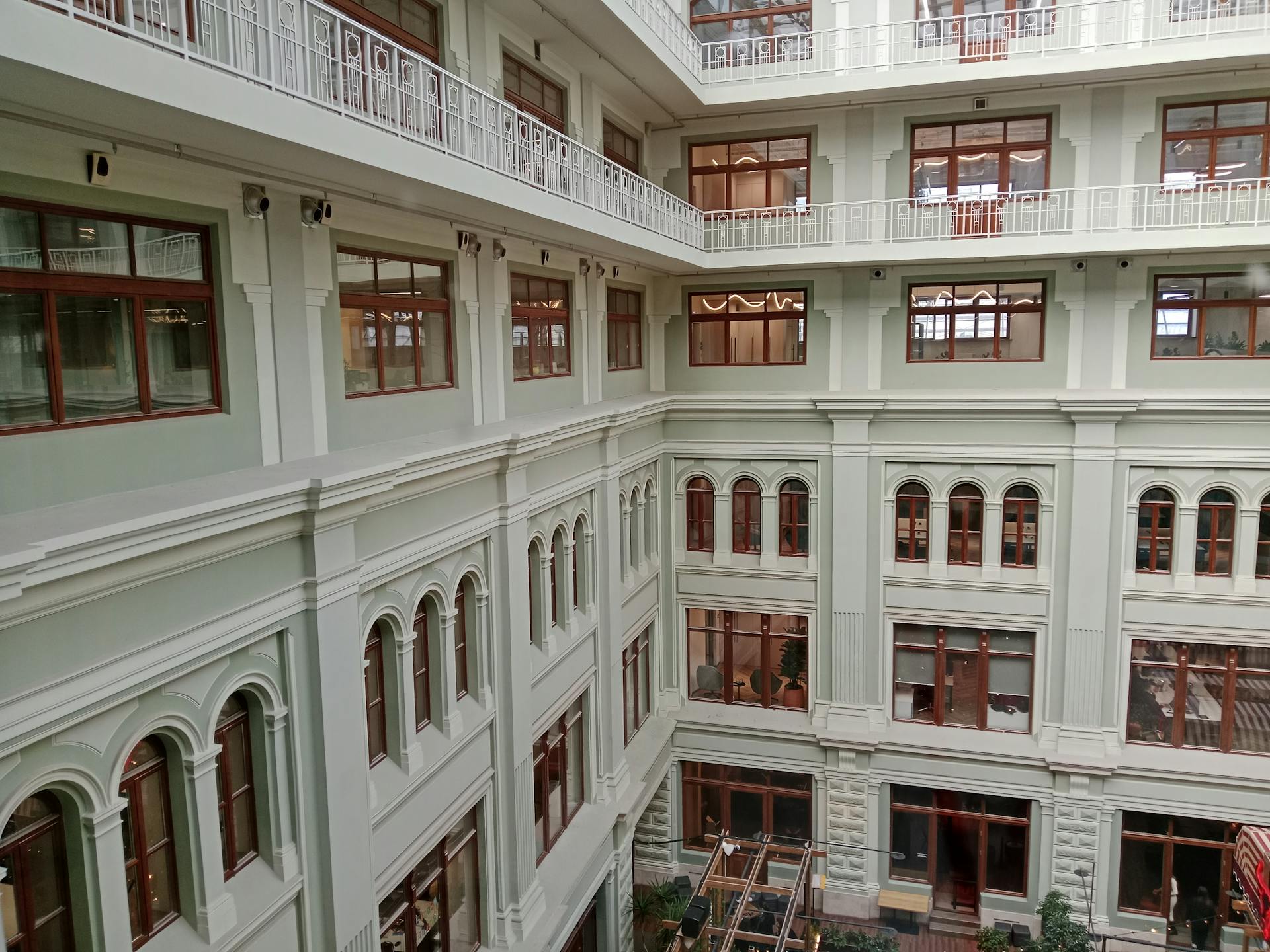 Elegant multi-level interior of a modern office building with large windows and intricate railings.