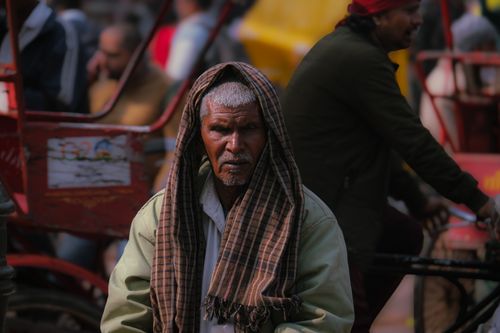 Free Portrait of an elderly man on the bustling streets of Delhi, India, capturing local life and culture. Stock Photo