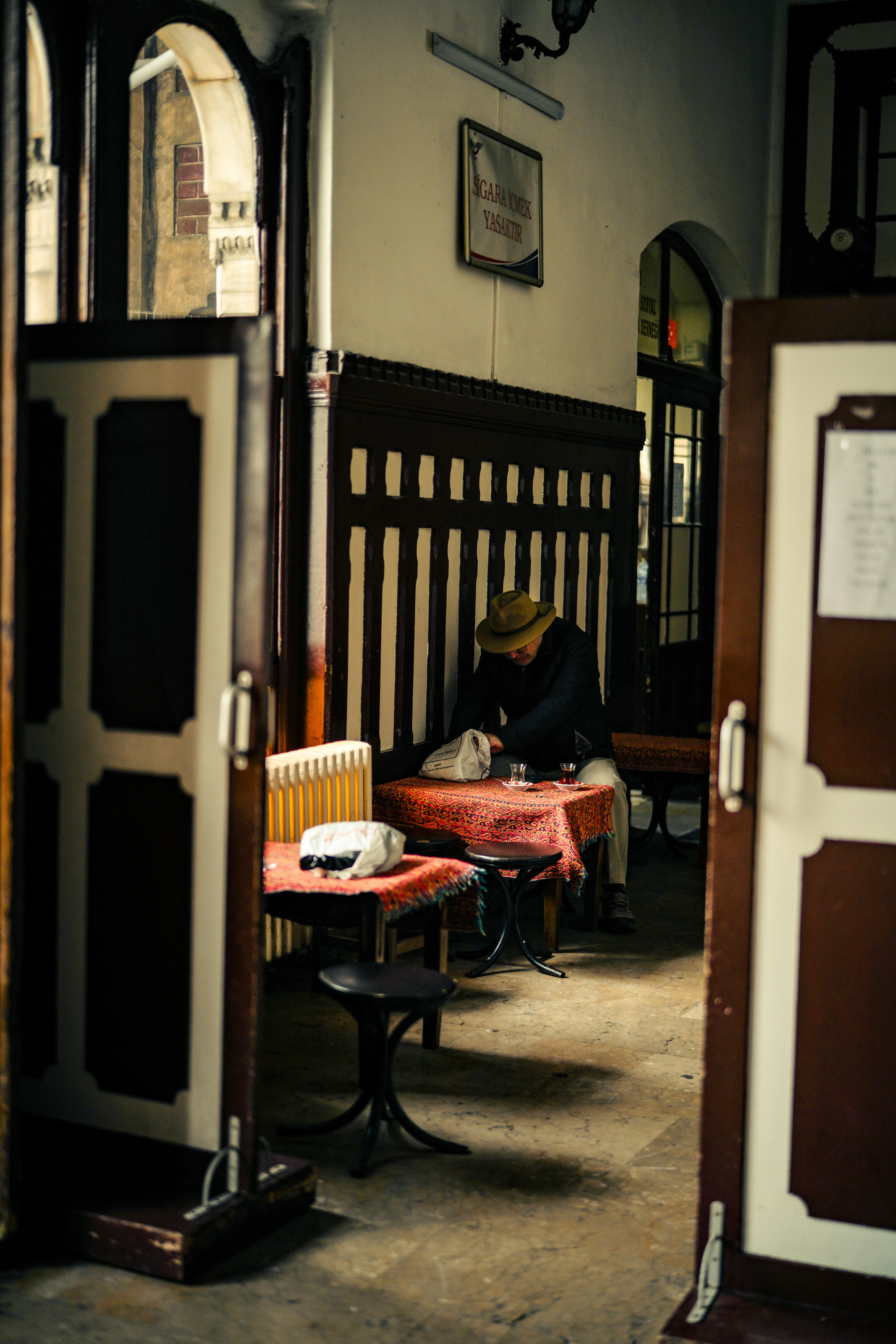 Gratuit O scenă capricioasă într-o cafenea vintage cu o singură persoană așezată, creând o ambianță reflectorizante. Fotografie de stoc