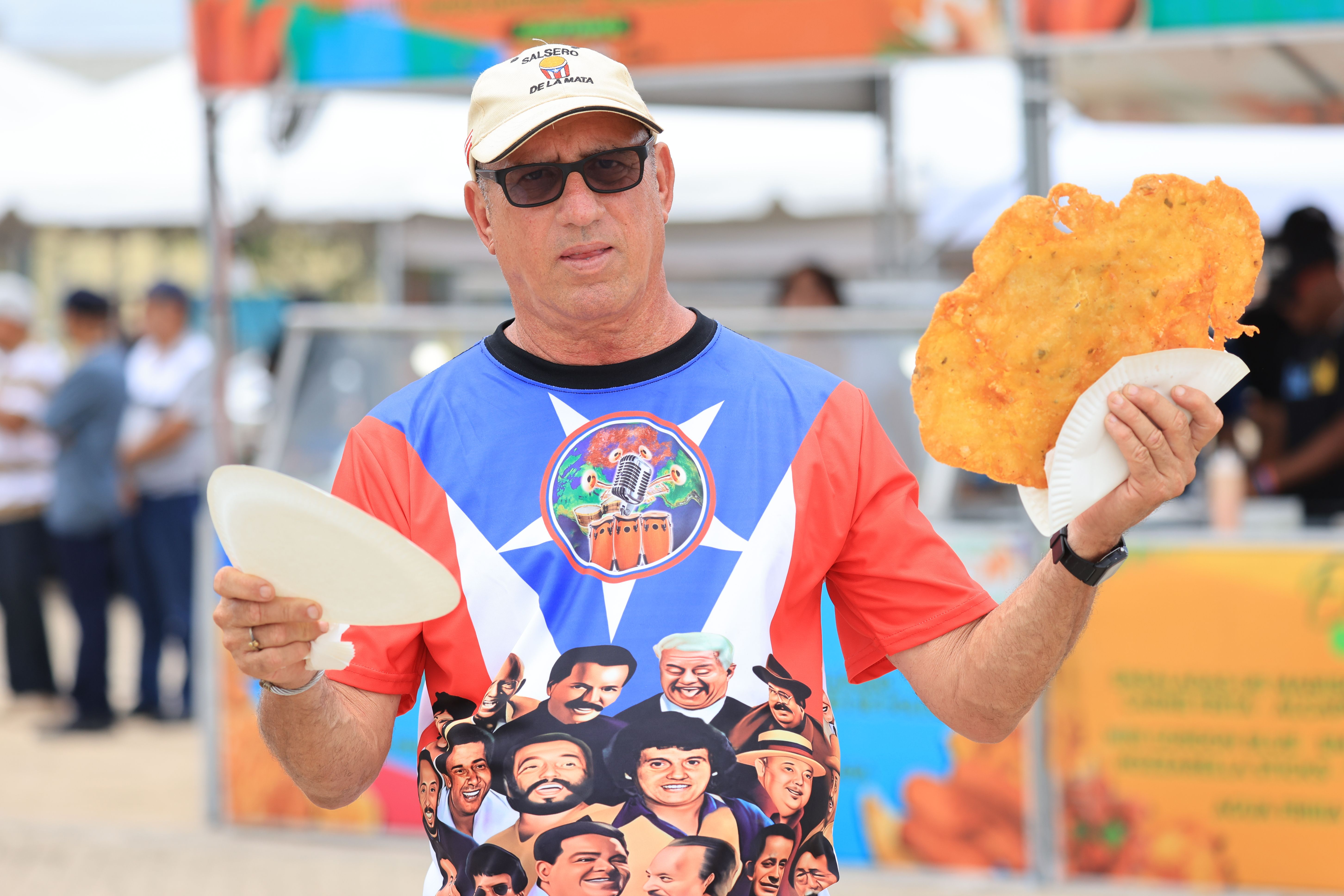 Man Holding a Large Crispy Snack at Outdoor Event · Free Stock Photo