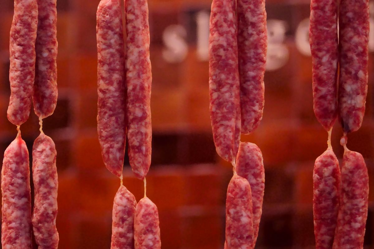 Cured sausages hanging in a traditional butcher shop